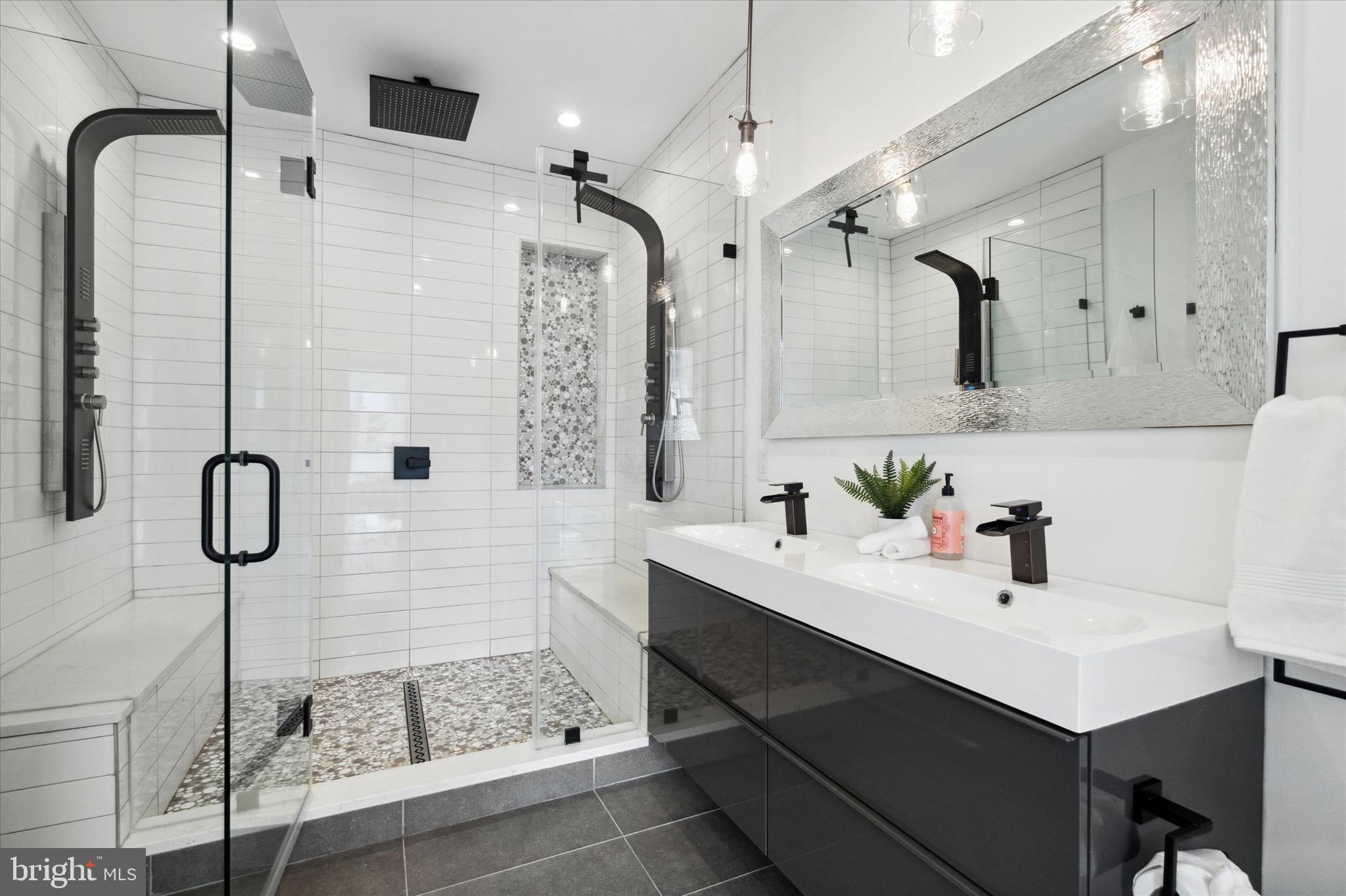 1825 Ginnodo Street, Unit R2 Philadelphia, PA 19130 - Photo 27 of 38 a bathroom with a sink a toilet a mirror and shower