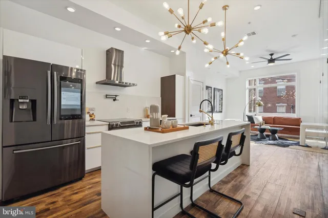 a kitchen with a sink stainless steel appliances and chandelier