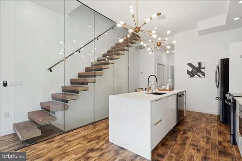 a living room with furniture a large window and wooden floor