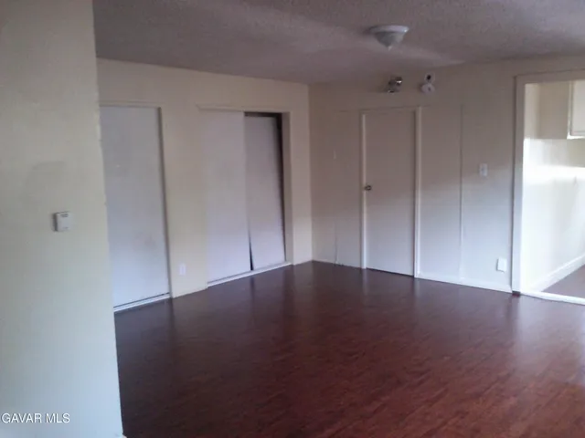 a view of an empty room with wooden floor