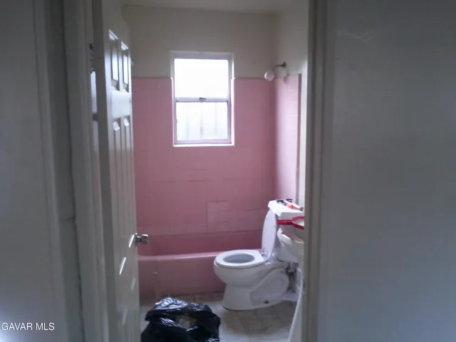 a bathroom with a toilet a sink and tub