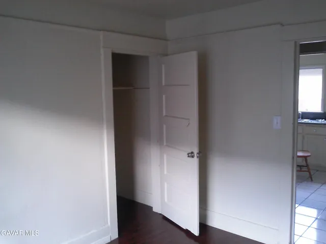 an empty room with wooden floor and closet