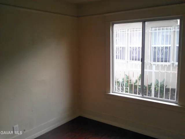 a view of a small space with wooden floor and a window