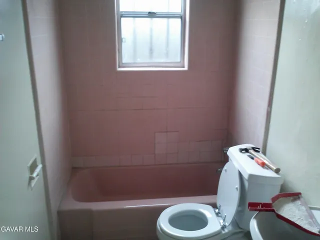 a bathroom with a sink toilet and window