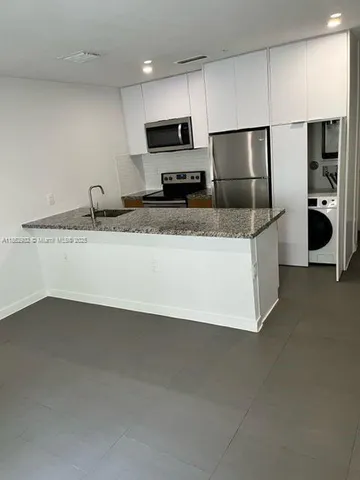 a kitchen with stainless steel appliances a refrigerator a sink a stove and microwave