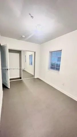 an empty room with a fireplace and window