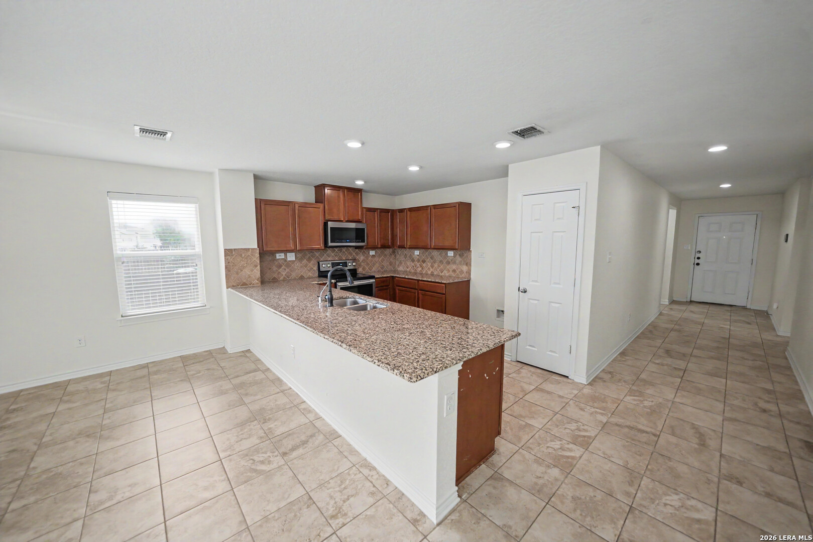 7506 Copper Cove Converse, TX 78109 - Photo 15 of 45 a large kitchen with kitchen island granite countertop a large counter top and tiles