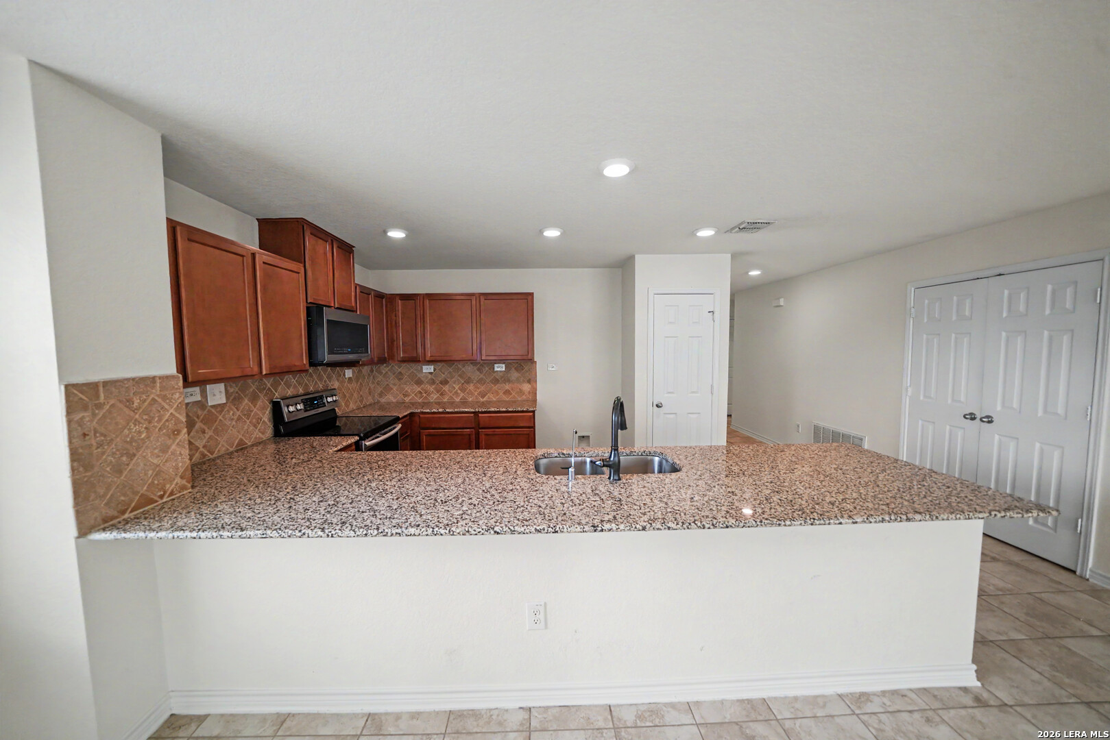 7506 Copper Cove Converse, TX 78109 - Photo 16 of 45 a kitchen with kitchen island granite countertop a sink and cabinets