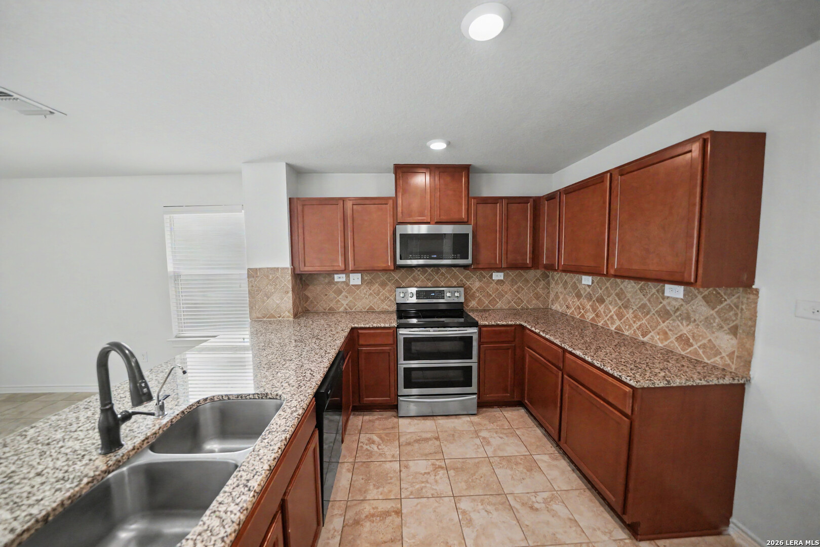7506 Copper Cove Converse, TX 78109 - Photo 17 of 45 a kitchen with stainless steel appliances granite countertop a sink stove and refrigerator