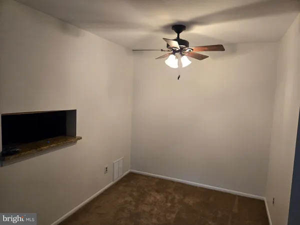 an empty room with a fan and a fan