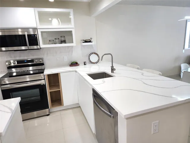 a kitchen with a sink cabinets and appliances
