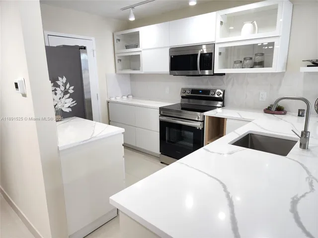 a kitchen with a sink a stove and microwave