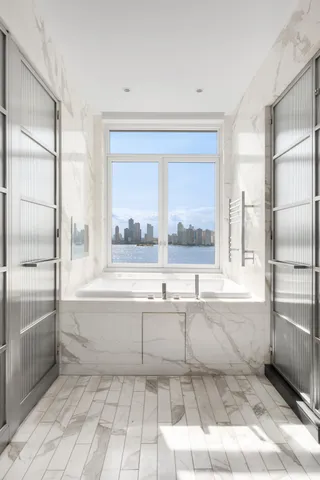 a bedroom with a bed and large windows