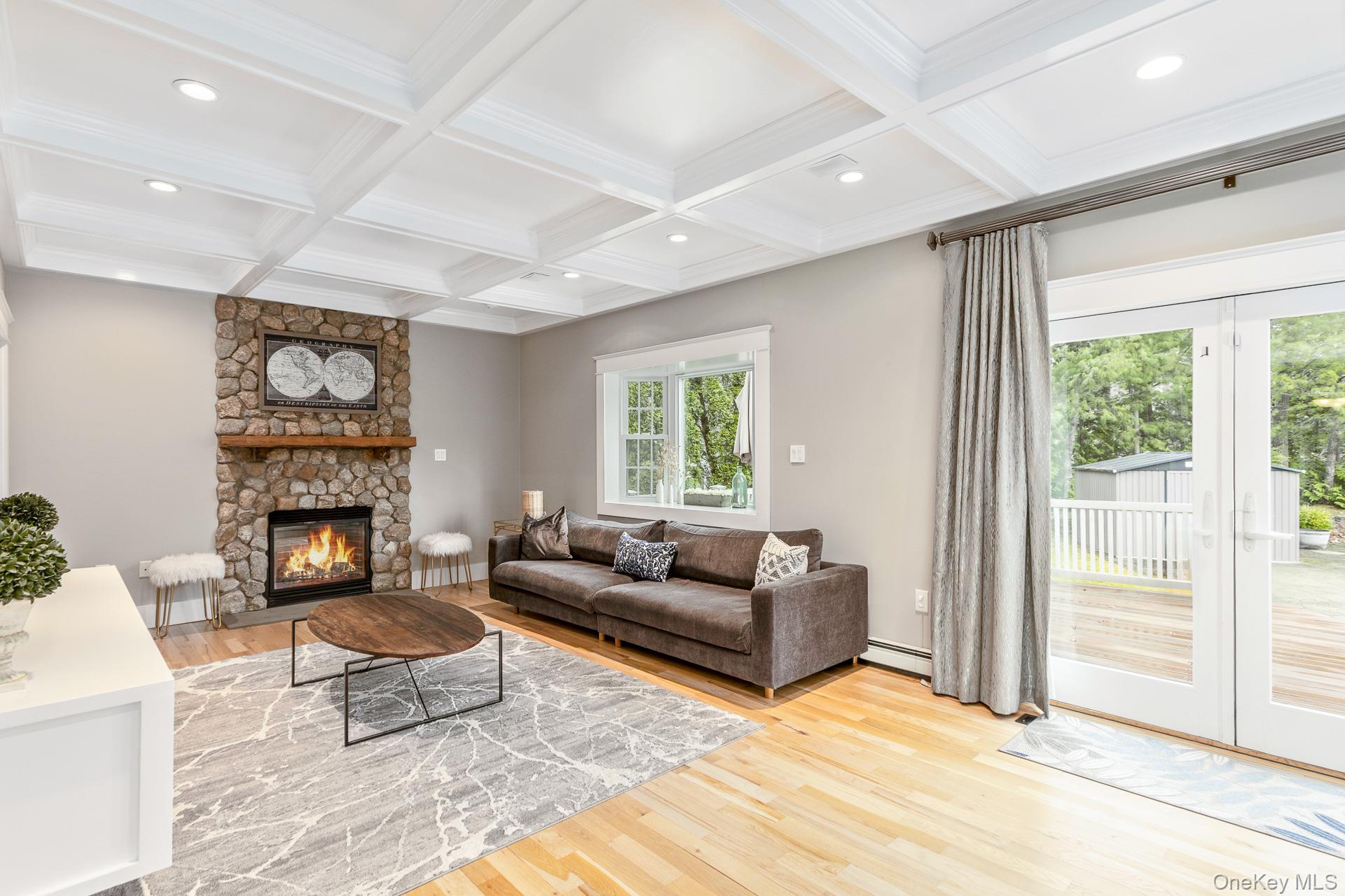 26 Box Tree Road East Quogue, NY 11942 - Photo 13 of 49 a living room with furniture a fireplace and a large window