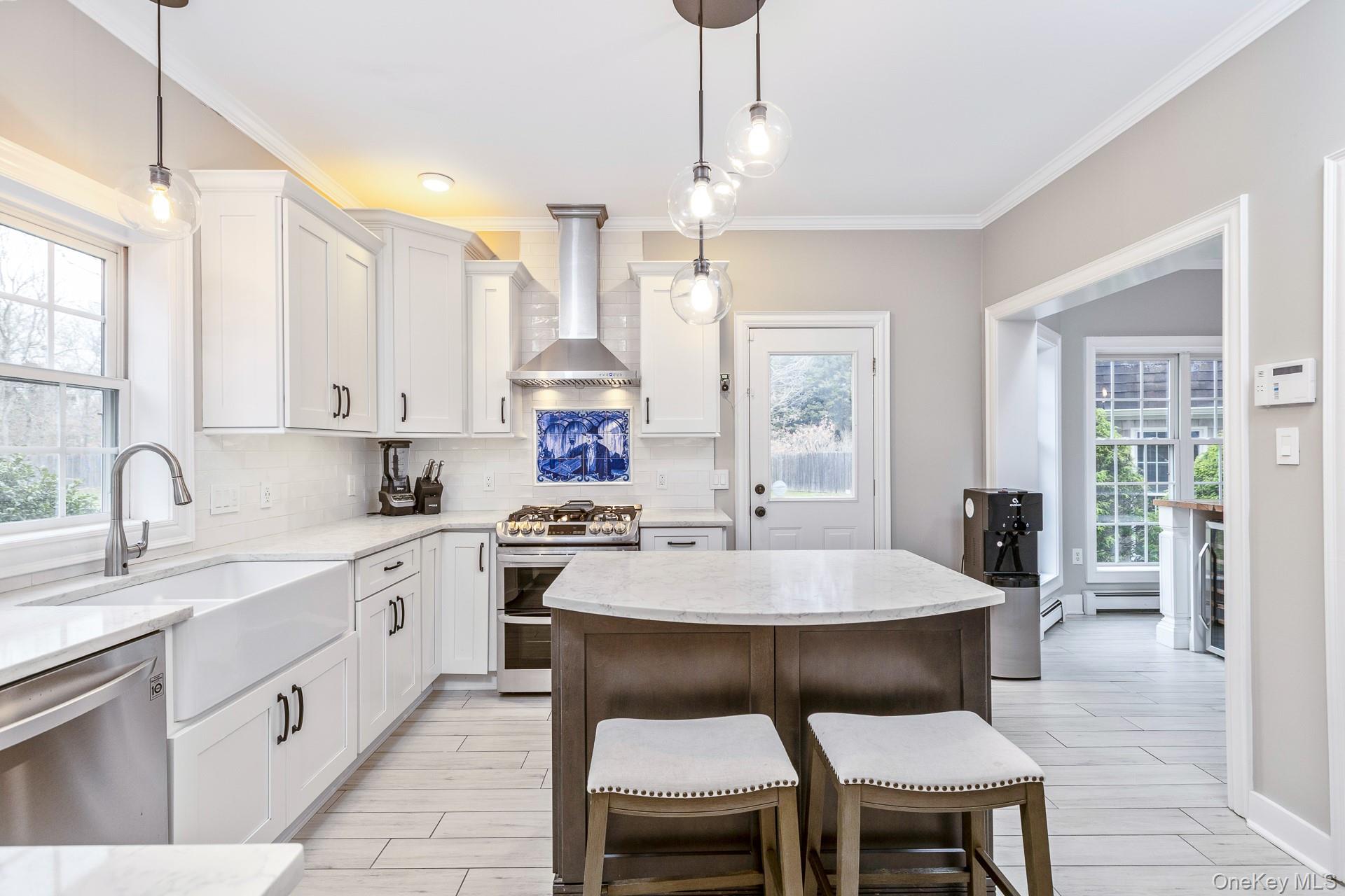 26 Box Tree Road East Quogue, NY 11942 - Photo 17 of 49 a large kitchen with a table and chairs in it