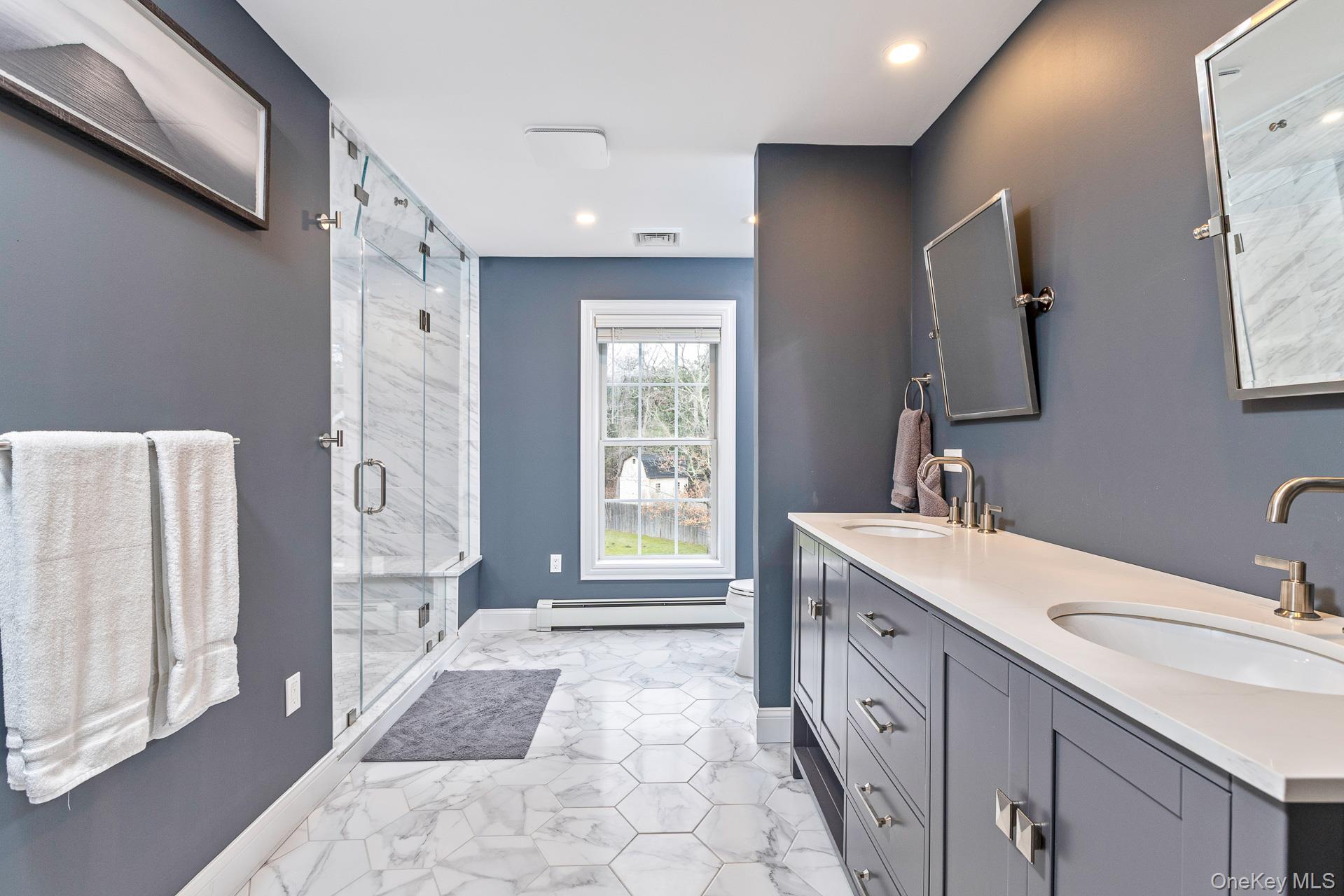 26 Box Tree Road East Quogue, NY 11942 - Photo 28 of 49 a spacious bathroom with a double vanity sink a large mirror a shower and a bathtub