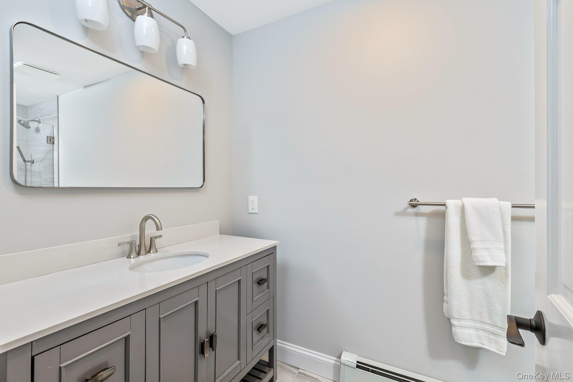 26 Box Tree Road East Quogue, NY 11942 - Photo 36 of 49 a bathroom with a sink a toilet and shower