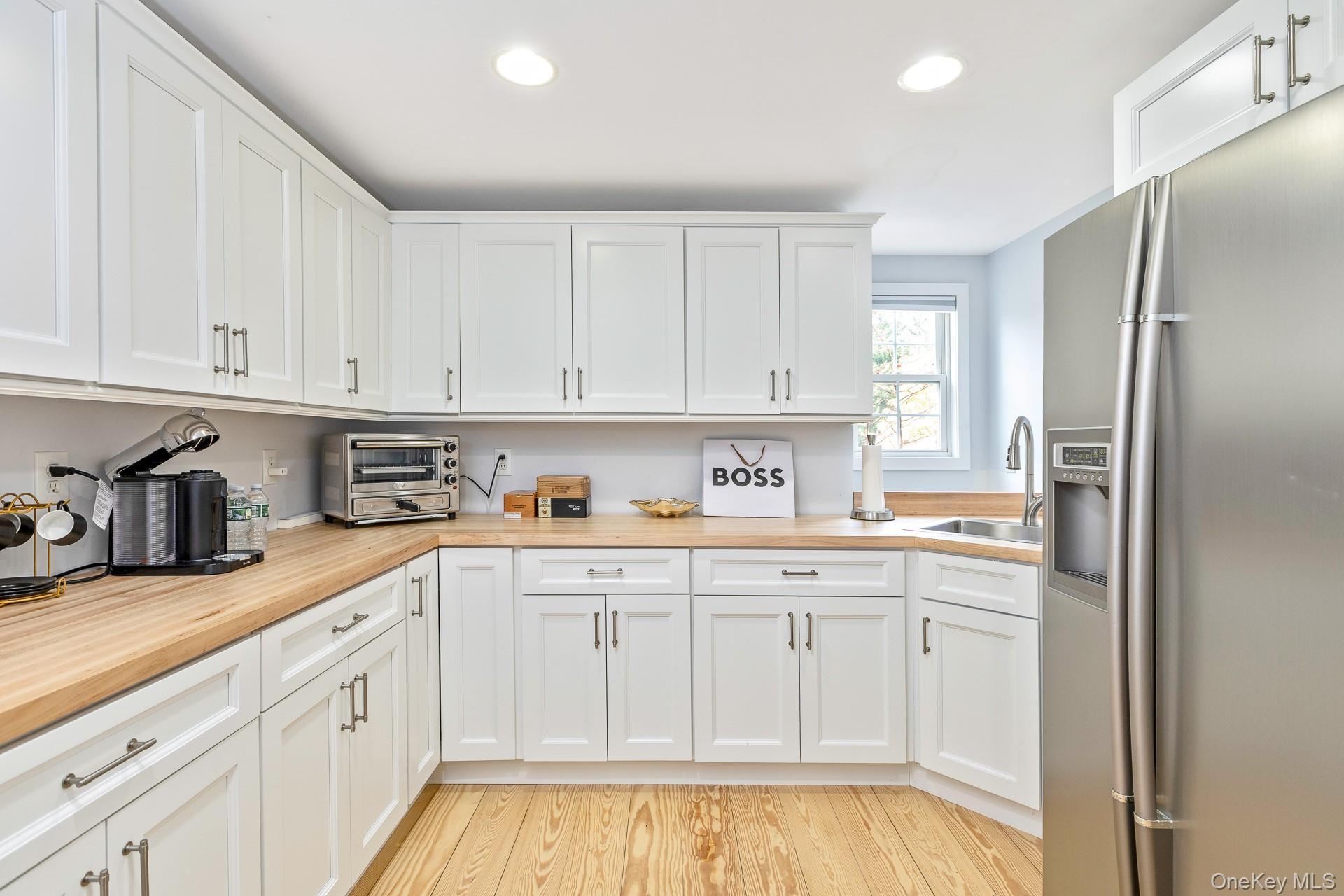 26 Box Tree Road East Quogue, NY 11942 - Photo 46 of 49 a kitchen with stainless steel appliances granite countertop a refrigerator and white cabinets