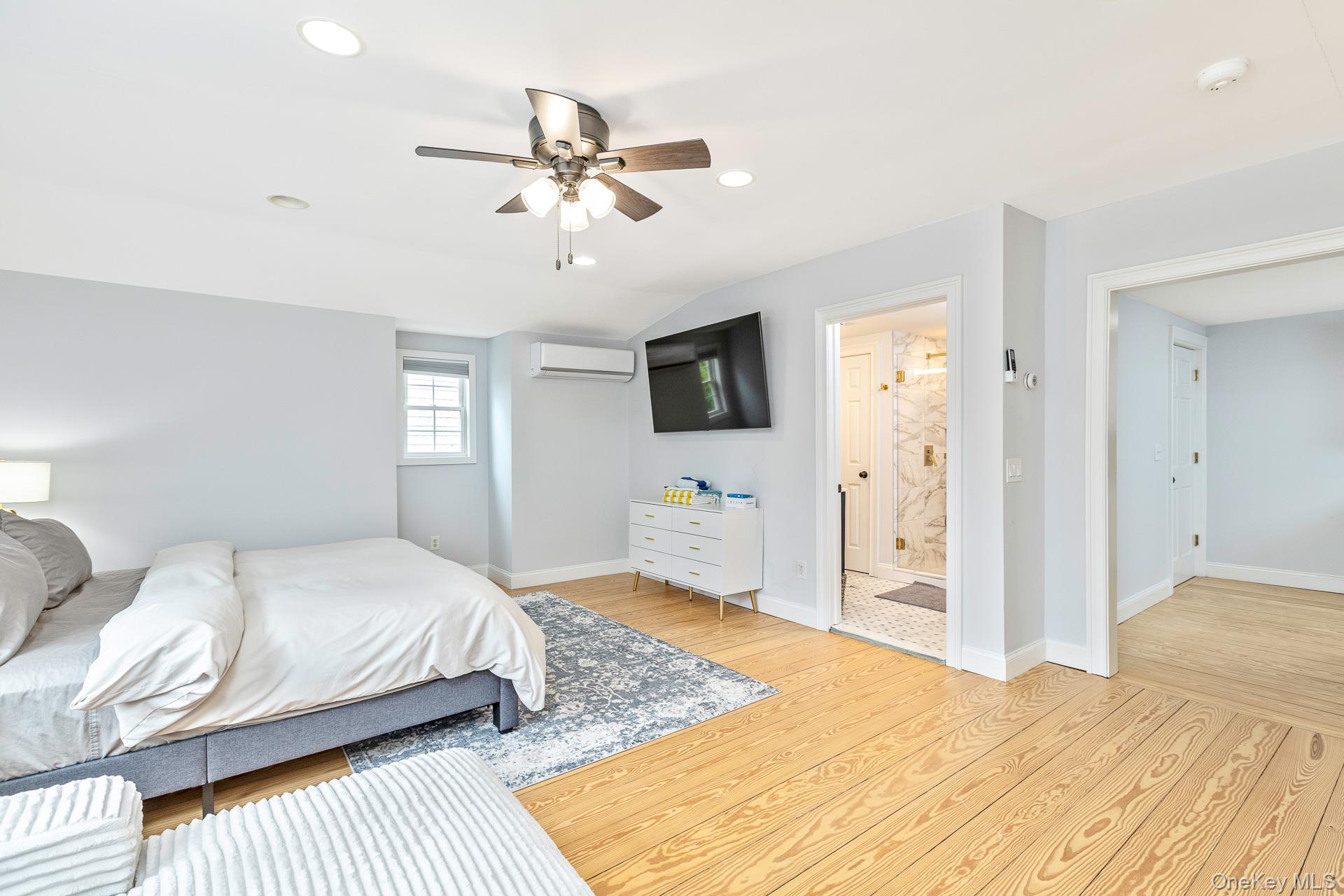 26 Box Tree Road East Quogue, NY 11942 - Photo 47 of 49 a bedroom with a bed and a chandelier
