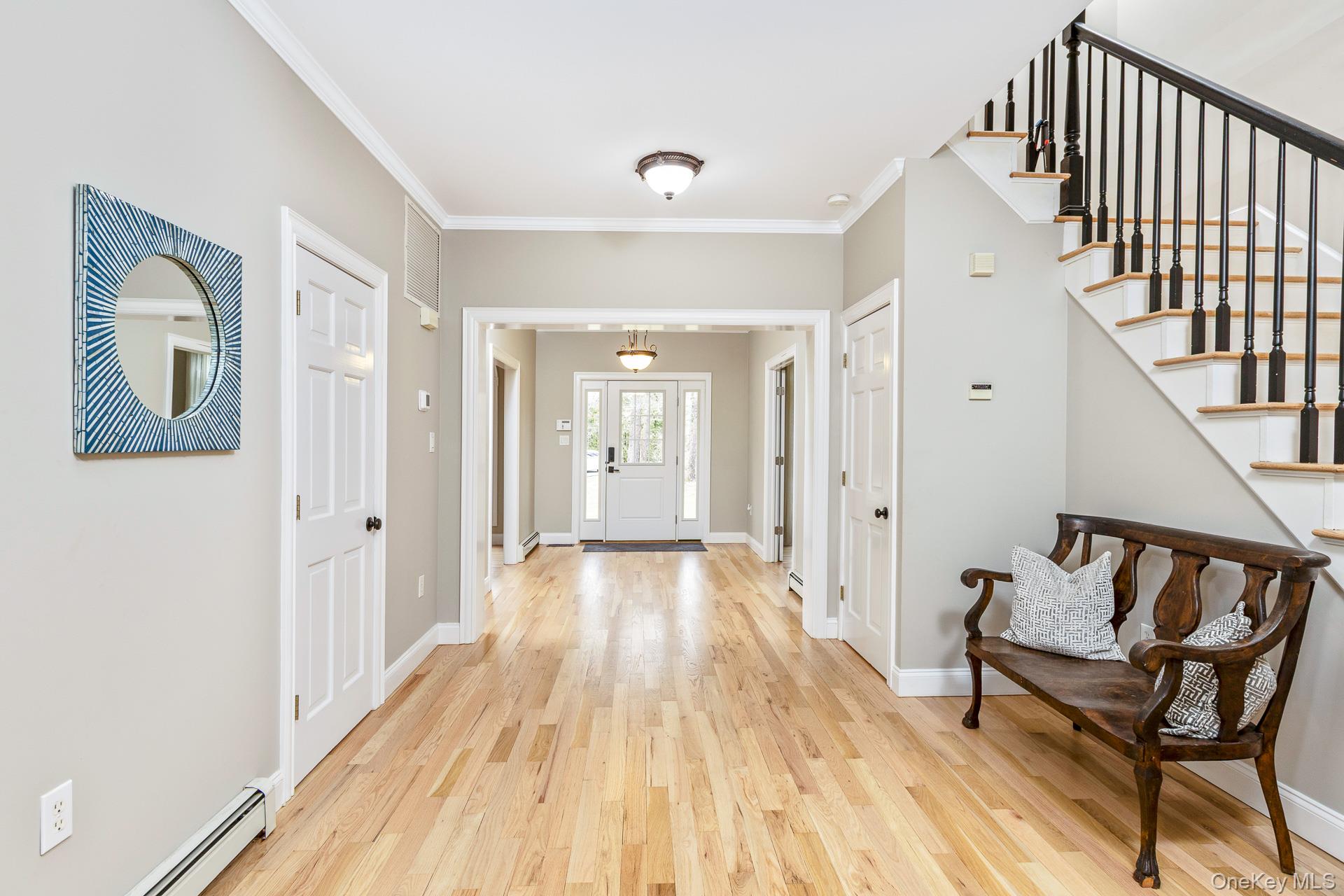 26 Box Tree Road East Quogue, NY 11942 - Photo 10 of 49 a view of a hallway with wooden floor and staircase