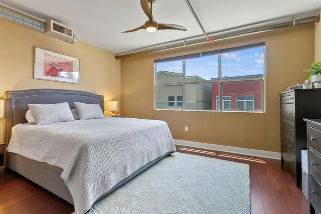 a bedroom with a bed and a flat tv screen on dresser