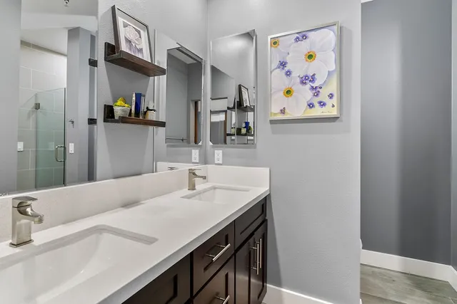 a bathroom with a sink a mirror and painting on the wall