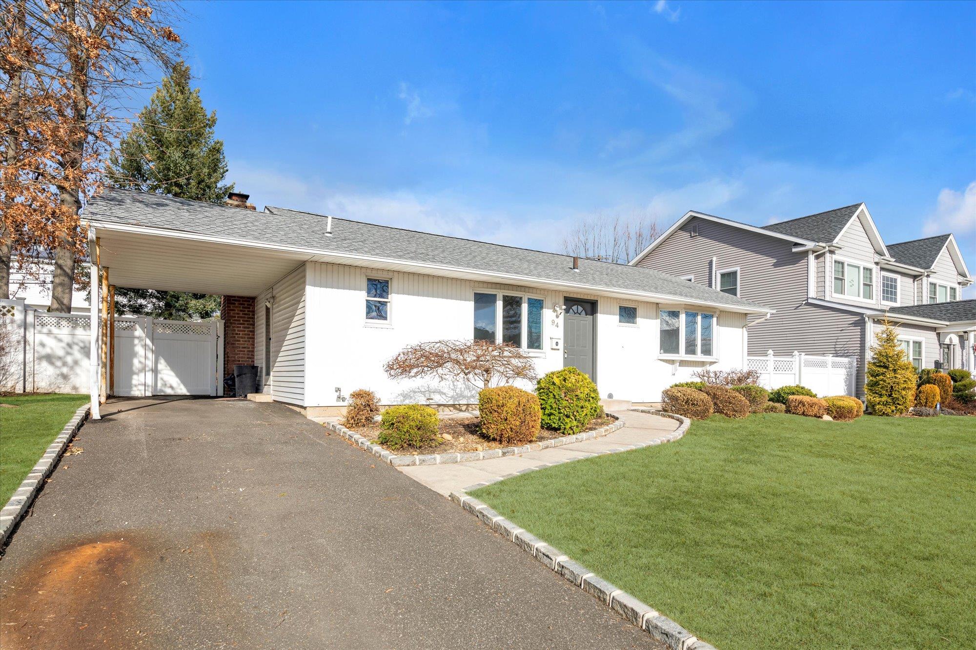 94 Georgia Drive Syosset, NY 11791 - Photo 1 of 1 View of front facade with a carport and a front lawn