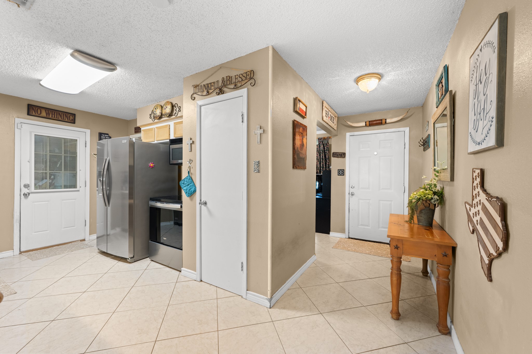 15602 Fir Road Santa Fe, TX 77517 - Photo 4 of 42 Functional layout with easy access between the kitchen, entryway, and main living areas, creating a seamless everyday flow. Stainless steel appliances, ample storage, and tile flooring add both style and practicality to the space.