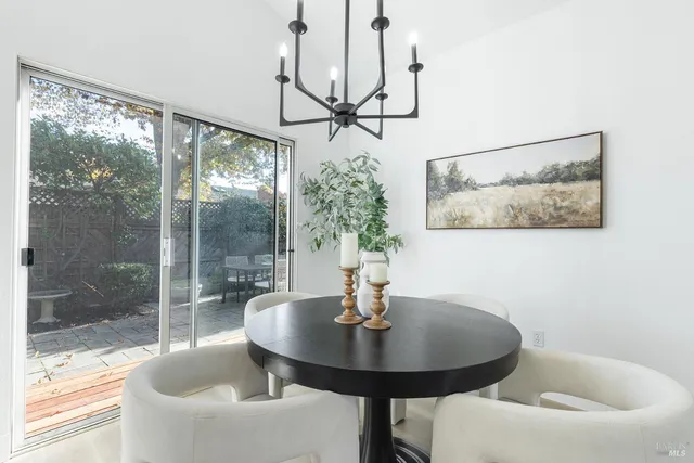 a dining room with glass top table and chairs