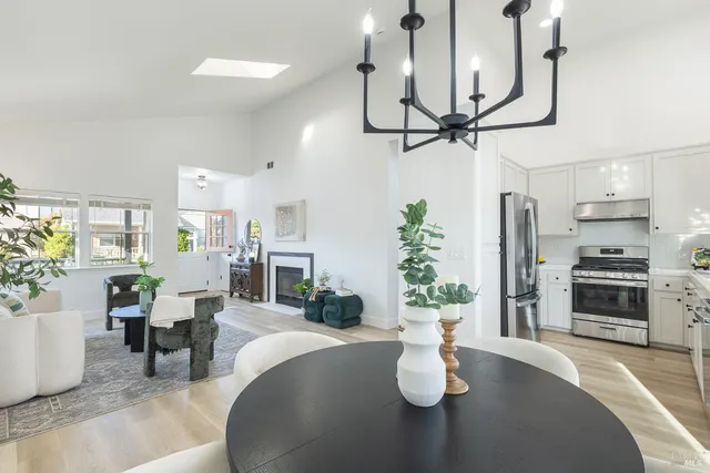 a dining room with furniture a chandelier and wooden floor