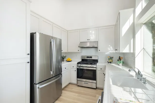 a kitchen with stainless steel appliances a refrigerator sink and stove