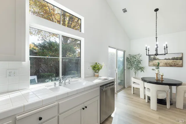 a dining table with a large window and chairs