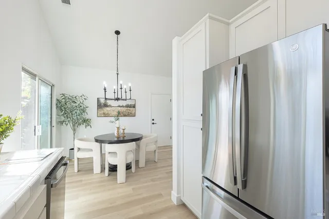a dining room with furniture a chandelier and wooden floor