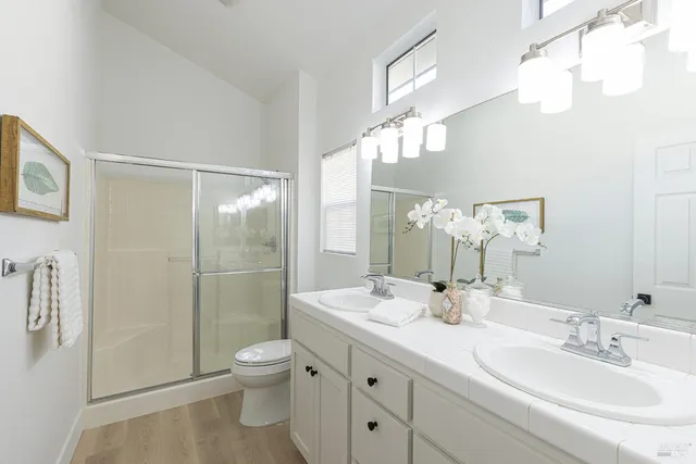 a bathroom with a double vanity sink toilet and shower