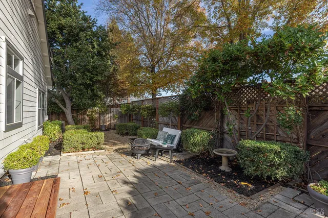 a view of backyard with table and chairs and potted plants
