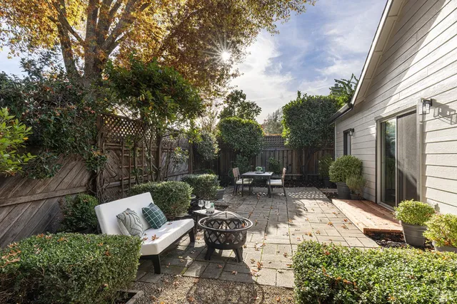 a view of a chair and tables in the backyard of the house