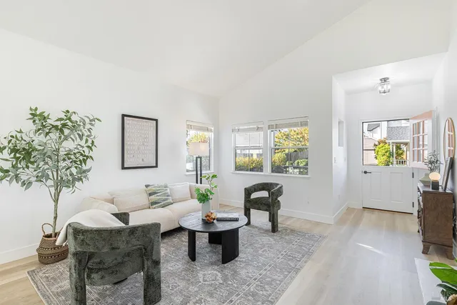 a living room with furniture a table and a potted plant