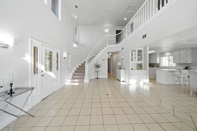 a kitchen with stainless steel appliances kitchen island granite countertop a sink a stove a refrigerator and white cabinets