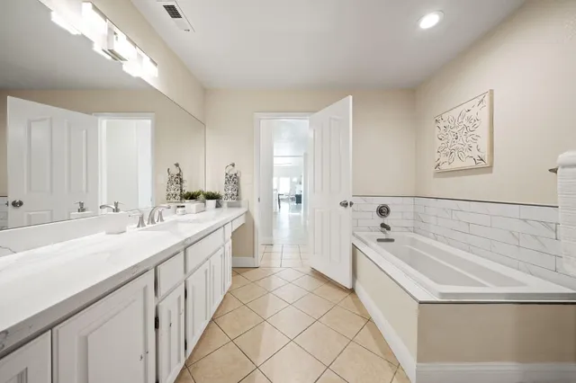 a bedroom with a white bed and white cabinets