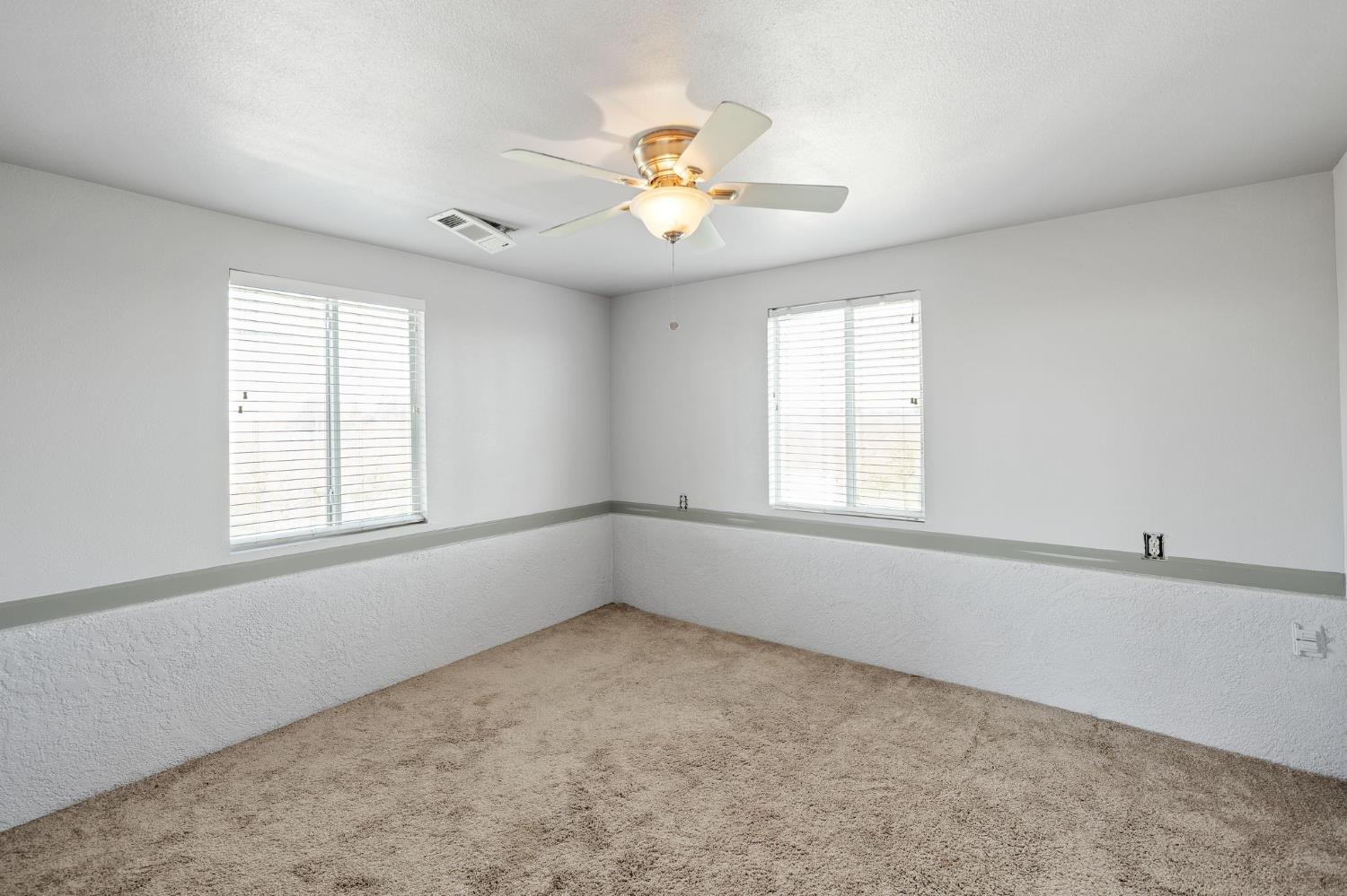 6312 Skittone Road Modesto, CA 95356 - Photo 70 of 93 an empty room with windows and chandelier fan