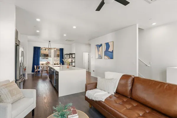 a living room with furniture and a view of kitchen