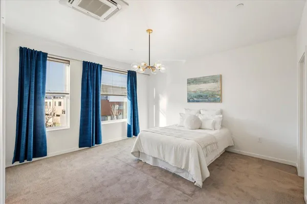 a bedroom with a large bed and a chandelier