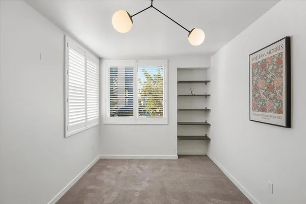 a view of a hallway with wooden floor and entryway