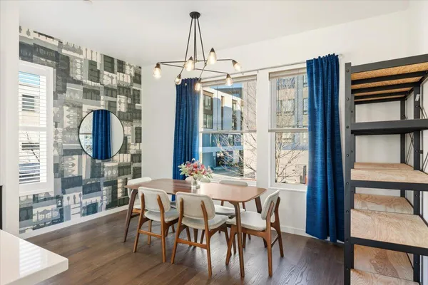 a dining room with furniture a chandelier and wooden floor