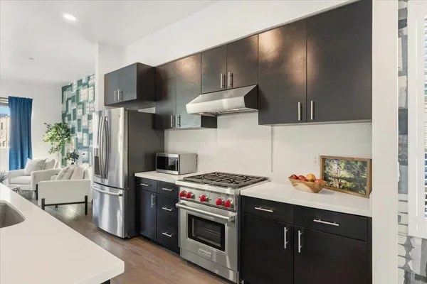 a kitchen with stainless steel appliances a stove a sink and a refrigerator