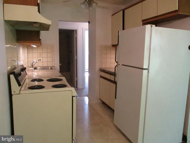 a white refrigerator freezer and a stove sitting inside of a kitchen