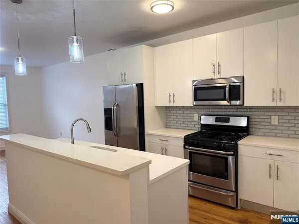a kitchen with kitchen island a sink appliances and cabinets