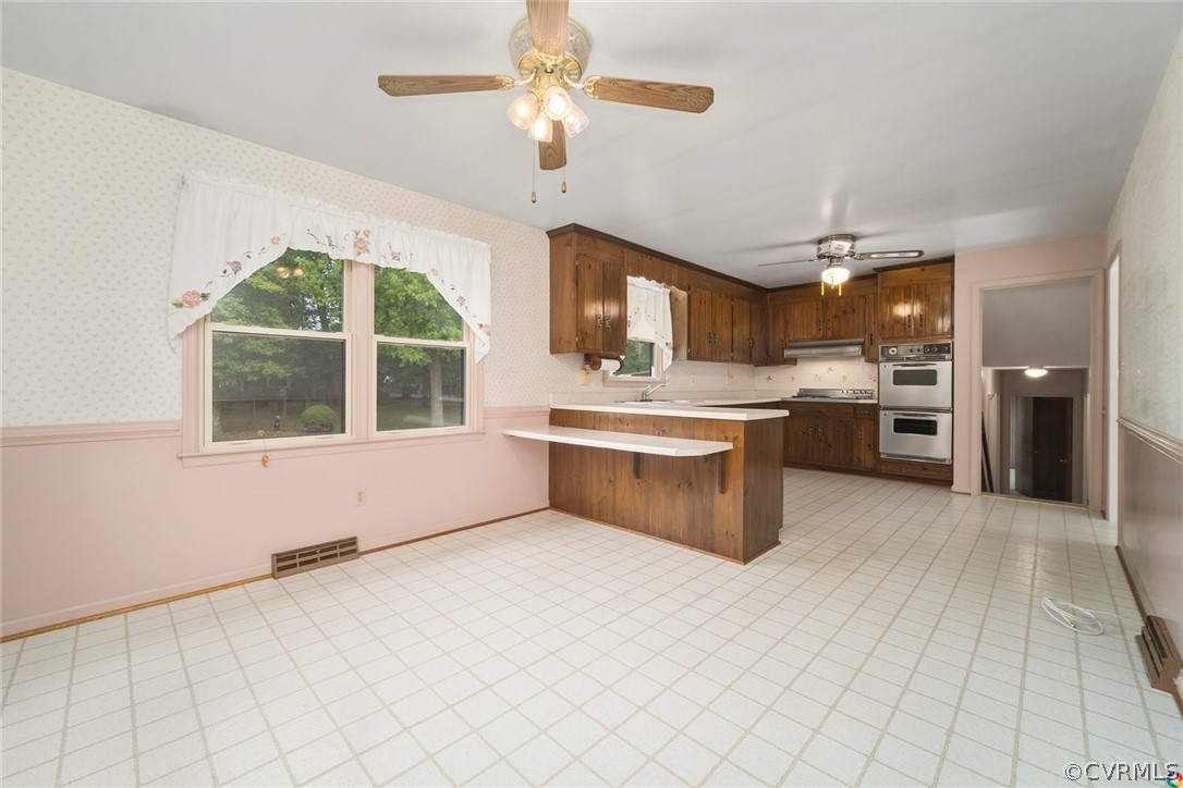13304 South Chester Road Chester, VA 23831 - Photo 14 of 46 a large white kitchen with a large window cabinets and stainless steel appliances