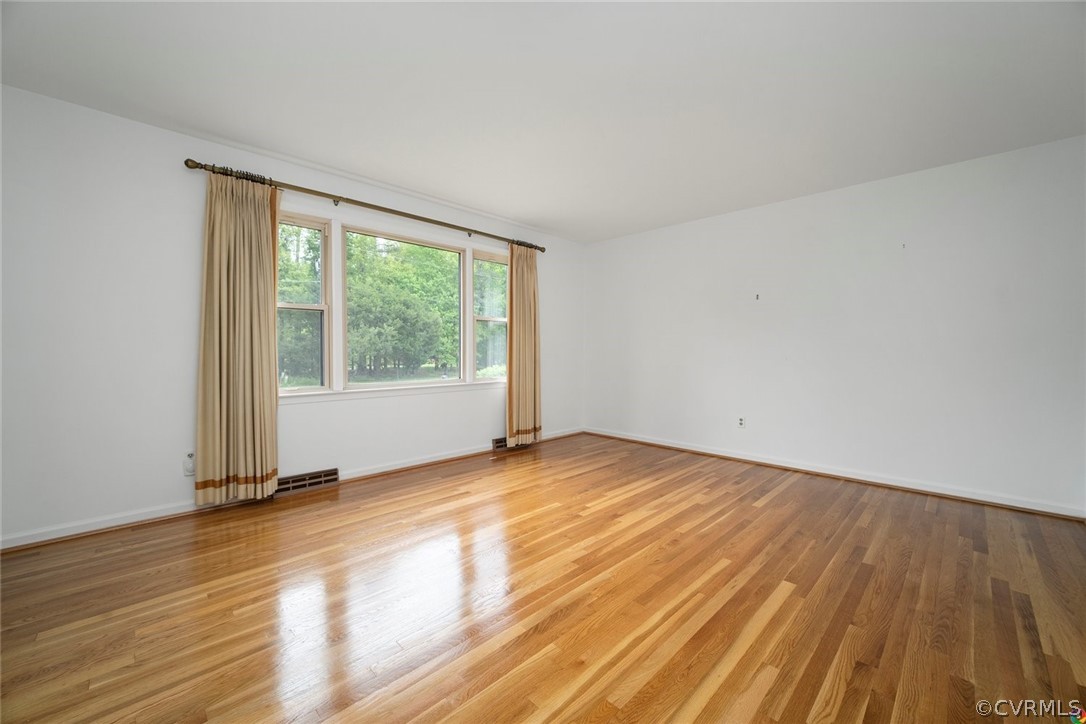 13304 South Chester Road Chester, VA 23831 - Photo 4 of 46 a view of an empty room with wooden floor and a window