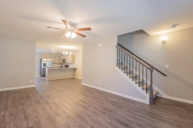 a view of a kitchen with wooden floor and a ceiling fan